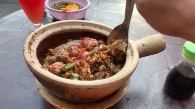 Claypot Tavuk Pirinç Çin Sosisi Asyalı erkek Çin Mahallesi Kuala Lumpur tarafından karıştırılıyor, Malezya. Bakış açısına göre akşam yemeği. Genellikle kömür yangınında pişirilir..