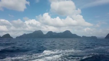 Coron 'dan El Nido' ya giden feribotun güvertesinden yeşil dağ adalarına ve tekneden gelen derin mavi okyanus dalgalarına bakın. 30 fps gerçek zamanlı UHD video H.264