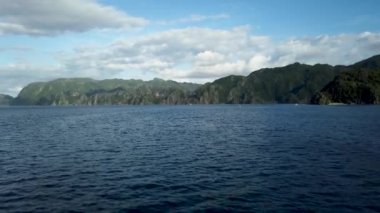 Coron 'dan El Nido' ya giden feribot güvertesinden yeşil dağ adalarına ve derin mavi okyanus suyuna bakan tekne manzarası. 30 fps gerçek zamanlı UHD video H.264