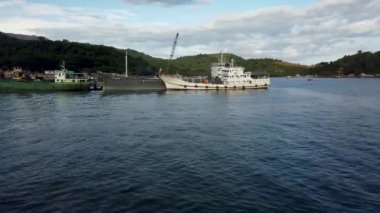 Coron, Filipinler: 26 Ekim 2019 - Bay Harbor limanına yolcu feribot iskelesi olarak giriş. Gözlem güvertesinden, kenetlenmiş kargo gemilerinin yanından geçerken....