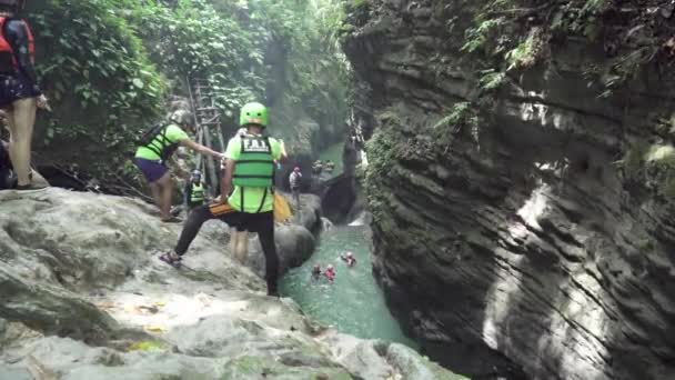 フィリピンのセブ アレグリア 2019年11月22日人は川山の滝で崖から水に飛び込みます キャニオニングは 観光客のための人気のあるグループアクションスポーツ活動です — ストック動画