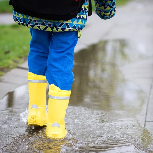 Παιδί στη βροχή μπότες περπάτημα στη λακκούβα — Φωτογραφία Αρχείου