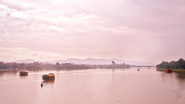 Barcos no rio solitário correr para transformar ondulações, as montanhas e as nuvens de distância é fazer a verdadeira paisagem de paz do campo em Hue — Fotografia de Stock