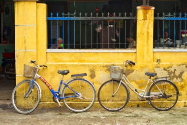 Hoi An, Vietnam - 06 Nisan 2017: Bisiklet Park caddenin Hoi An antik şehrin eski evde sarı duvara