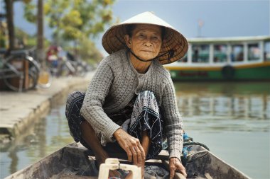 Hoi An, Vietnam - 11 Nisan 2017: Hoi tarih Prş Bon Nehri'nde ahşap teknede geleneksel şapka ile Vietnam kadın An, Vietnam