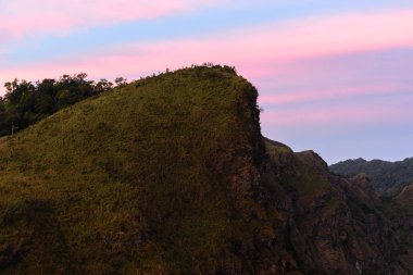 Dağ tepe üzerinde günbatımında zamları.