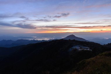 Güzel bir yer, dağ tepe batımında kamp sitesinden duman kamp ateşi.