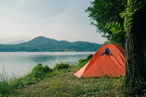 Parque de campismo de tenda laranja perto do lago com vista panorâmica . — Fotografia de Stock