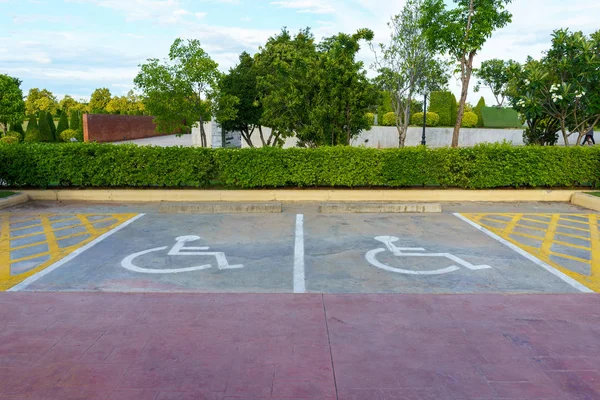 Sinal de cadeira de rodas no parque de estacionamento reservado para aleijados . — Fotografia de Stock