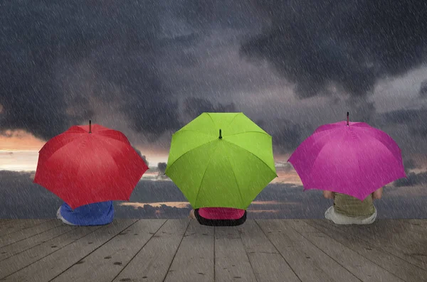Three color umbrellas in the rain