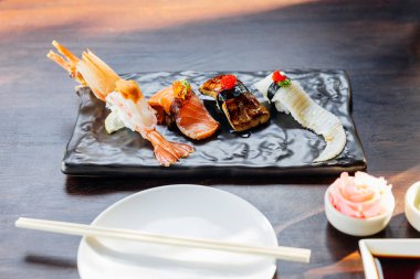 En iyi sushi seti 'nde wasabi ve pembe turşulu zencefil ile servis edilen Black Stone Plate' de Deniz kestanesi, kaz ciğeri, somon ve Engawa bulunmaktadır..