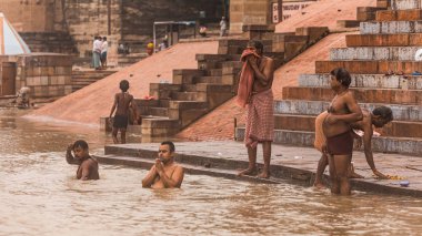 Hintliler Varanasi, Uttar Pradesh, Hindistan 'daki eski binalarla Ganj (Ganga) nehrinde yaşar, dua eder ve banyo yaparlar..