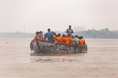 Hintli kürekçi, Hindistan 'ın Uttar Pradesh kentindeki Ganj (Ganga) nehrinde yüzen teknede turuncu bez kürekçilerini eğitiyor..