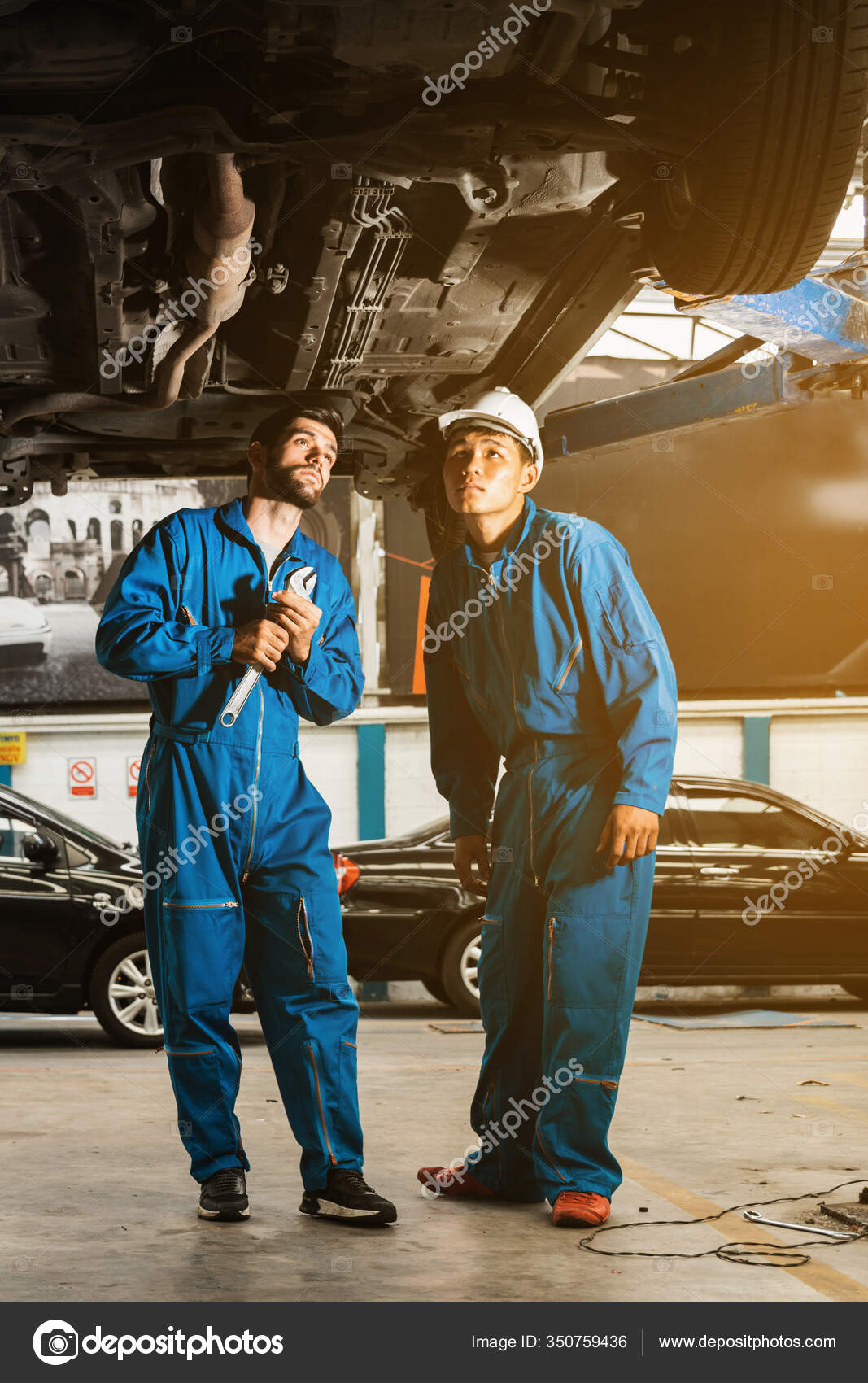Mecanico Uniforme Trabajo Azul Inspecciona Parte Inferior Del Coche Con Foto de stock 350759436 artitwpd