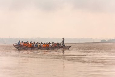 Hintli kürekçi, Hindistan 'ın Uttar Pradesh kentindeki Ganj (Ganga) nehrinde yüzen teknede turuncu bez kürekçilerini eğitiyor..