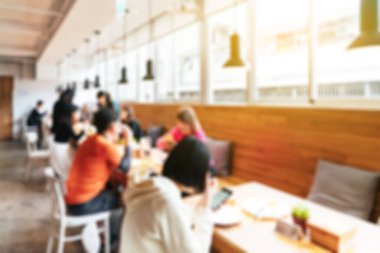 Interior blurred background: Customers sit in the chair and wooden table at the cafe with bright light in the morning in blur background with bokeh. Abstract blur interior room banner. Taipei, Taiwan.