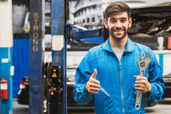 Mechaniker Stehen Und Halten Einen Schraubenschlüssel Mit Verschwommener Garage Hintergrund — Stockfoto