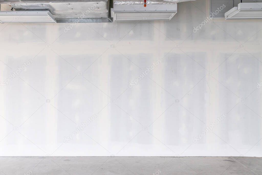 Drywall background during interior renovation with open ceiling system work. Drywall is gypsum wall with joints at the building site. Empty space for developer investment.