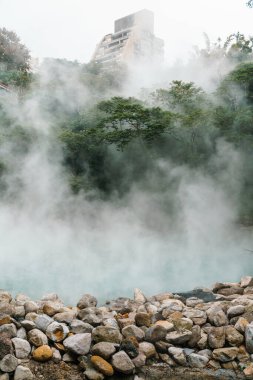 Beitou Park 'taki ünlü Beitou Termal Vadisi Tayvan' ın Taipei şehrindeki ağaçların arasında kaynayan kaplıcadan çıkan buhar..