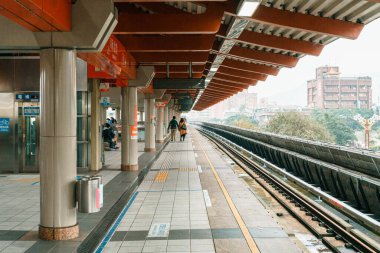 Taipei Beitou Metro İstasyonu 'nda tren bekleyen insanlar var. Toplu taşıma. Kültürel tasarıma sahip çağdaş mimari.