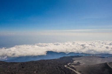 Etna Dağı volkanik kraterindeki uçan drone 'un hava görüntüsü kraterlerinden biri volkanik aktivite nedeniyle kabaca yerde dairesel bir çöküntü ve genellikle kase şeklinde yürüyen insanları da gösteriyor.