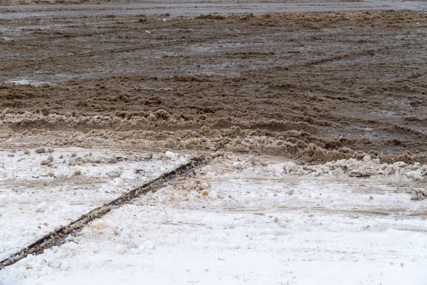 Şehir caddesi kar ve kirli lastik izleri ile kaplı ve kışın hafif patikalar, panoramik arka plan