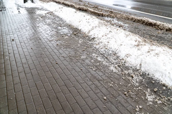 Şehir caddesi kar ve kirli lastik izleri ile kaplı ve kışın hafif patikalar, panoramik arka plan