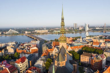 Daugava Nehri 'nin arka planında ve şehir merkezinde bulunan St. Peter Kilisesi' ne uçan insansız hava aracı panoramik görüntüsü (dizi).)