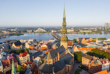 Daugava Nehri 'nin arka planında ve şehir merkezinde bulunan St. Peter Kilisesi' ne uçan insansız hava aracı panoramik görüntüsü (dizi).)