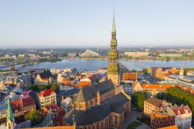 Daugava Nehri 'nin arka planında ve şehir merkezinde bulunan St. Peter Kilisesi' ne uçan insansız hava aracı panoramik görüntüsü (dizi).)