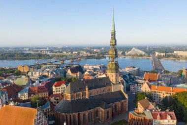 Daugava Nehri 'nin arka planında ve şehir merkezinde bulunan St. Peter Kilisesi' ne uçan insansız hava aracı panoramik görüntüsü (dizi).)
