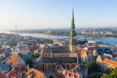 Daugava Nehri 'nin arka planında ve şehir merkezinde bulunan St. Peter Kilisesi' ne uçan insansız hava aracı panoramik görüntüsü (dizi).)