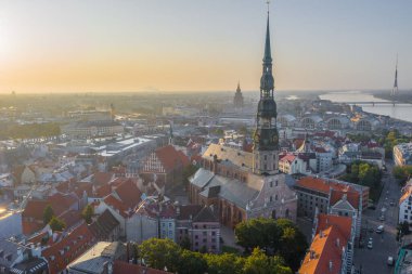 Daugava Nehri 'nin arka planında ve şehir merkezinde bulunan St. Peter Kilisesi' ne uçan insansız hava aracı panoramik görüntüsü (dizi).)