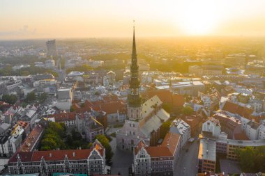 Daugava Nehri 'nin arka planında ve şehir merkezinde bulunan St. Peter Kilisesi' ne uçan insansız hava aracı panoramik görüntüsü (dizi).)