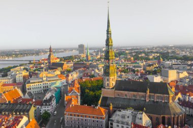 Daugava Nehri 'nin arka planında ve şehir merkezinde bulunan St. Peter Kilisesi' ne uçan insansız hava aracı panoramik görüntüsü (dizi).)