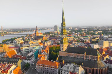 Daugava Nehri 'nin arka planında ve şehir merkezinde bulunan St. Peter Kilisesi' ne uçan insansız hava aracı panoramik görüntüsü (dizi).)