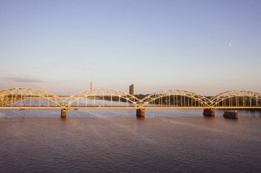 Riga, Letonya 12 Temmuz 2019: İHA 'dan Riga' daki Daugava nehri üzerindeki demiryolu köprüsüne giden hava manzaralı fotoğraf. Letonya 'da tatil zamanı. Baltık Eyaletleri 'nde sıcak bir yaz. (seri)