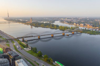 Riga, Letonya 12 Temmuz 2019: İHA 'dan Riga' daki Daugava nehri üzerindeki demiryolu köprüsüne giden hava manzaralı fotoğraf. Letonya 'da tatil zamanı. Baltık Eyaletleri 'nde sıcak bir yaz. (seri)