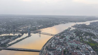 Riga, Letonya 'da güneşli bir yaz gününde uçakla Riga' nın köprülerinin, Daugava Nehri 'nin, TV Kulesinin ve şehrin gökyüzünün panoramik görüntüsünü gösteren hava görüntüsü. (seri)