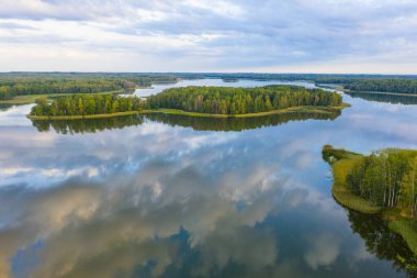 Aglona küçük kasabasına ve yazın güzel Latgale göllerine. Gölün yansıması muhteşem bulutlar ve gökyüzü. Aglona, Latgale, Letonya (dizi)