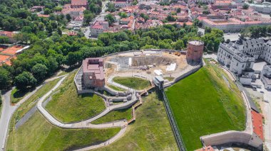 Litvanya 'nın başkenti Vilnius' taki Gediminas kalesinde uçan dron 'dan güzel panoramik hava manzaralı fotoğraf. Kulede Litvanya bayrağı, arka planda da şehir merkezinin silüeti. (seri)