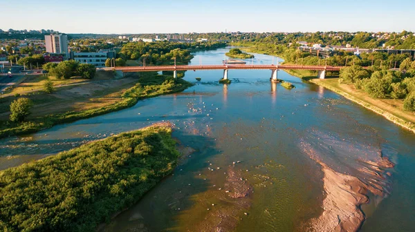 Beautiful panoramic aerial view photo from flying drone to the Nemunas River and Petras Vileiis Bridge. Kaunas, Lithuania (series)