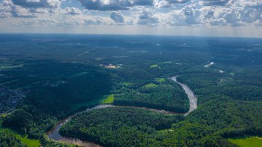 Sigulda 'nın güzel ormanları, çayırlar ve akan Gauja nehri üzerinde uçan dron' dan panoramik hava manzaralı fotoğraf. Sigulda, Letonya yazın)