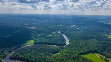 Sigulda 'nın güzel ormanları, çayırlar ve akan Gauja nehri üzerinde uçan dron' dan panoramik hava manzaralı fotoğraf. Sigulda, Letonya yazın)