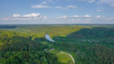 Sigulda 'nın güzel ormanları, çayırlar ve akan Gauja nehri üzerinde uçan dron' dan panoramik hava manzaralı fotoğraf. Sigulda, Letonya yazın)