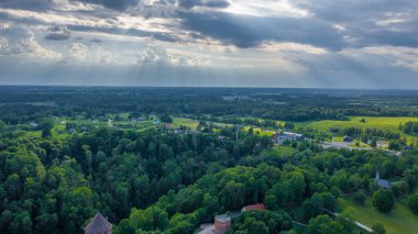 Sigulda 'nın güzel ormanları, çayırlar ve akan Gauja nehri üzerinde uçan dron' dan panoramik hava manzaralı fotoğraf. Sigulda, Letonya yazın)