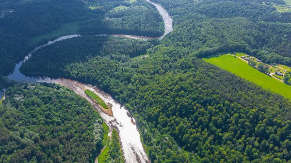 Sigulda 'nın güzel ormanları, çayırlar ve akan Gauja nehri üzerinde uçan dron' dan panoramik hava manzaralı fotoğraf. Sigulda, Letonya yazın)
