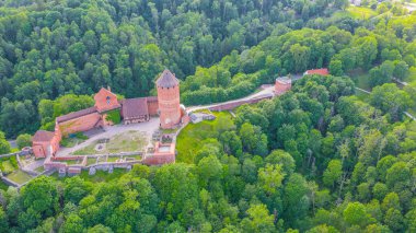 Güneşli bir yaz günü Sigulda, Letonya 'da, Turaida Kalesi' nin ortasında, Gauja Nehri üzerinde uçan dronun panoramik hava görüntüsü. (seri)