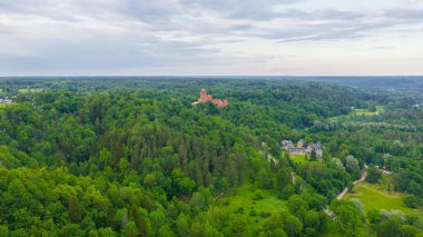 Güneşli bir yaz günü Sigulda, Letonya 'da, Turaida Kalesi' nin ortasında, Gauja Nehri üzerinde uçan dronun panoramik hava görüntüsü. (seri)
