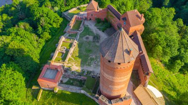 Güneşli bir yaz günü Sigulda, Letonya 'da, Turaida Kalesi' nin ortasında, Gauja Nehri üzerinde uçan dronun panoramik hava görüntüsü. (seri)